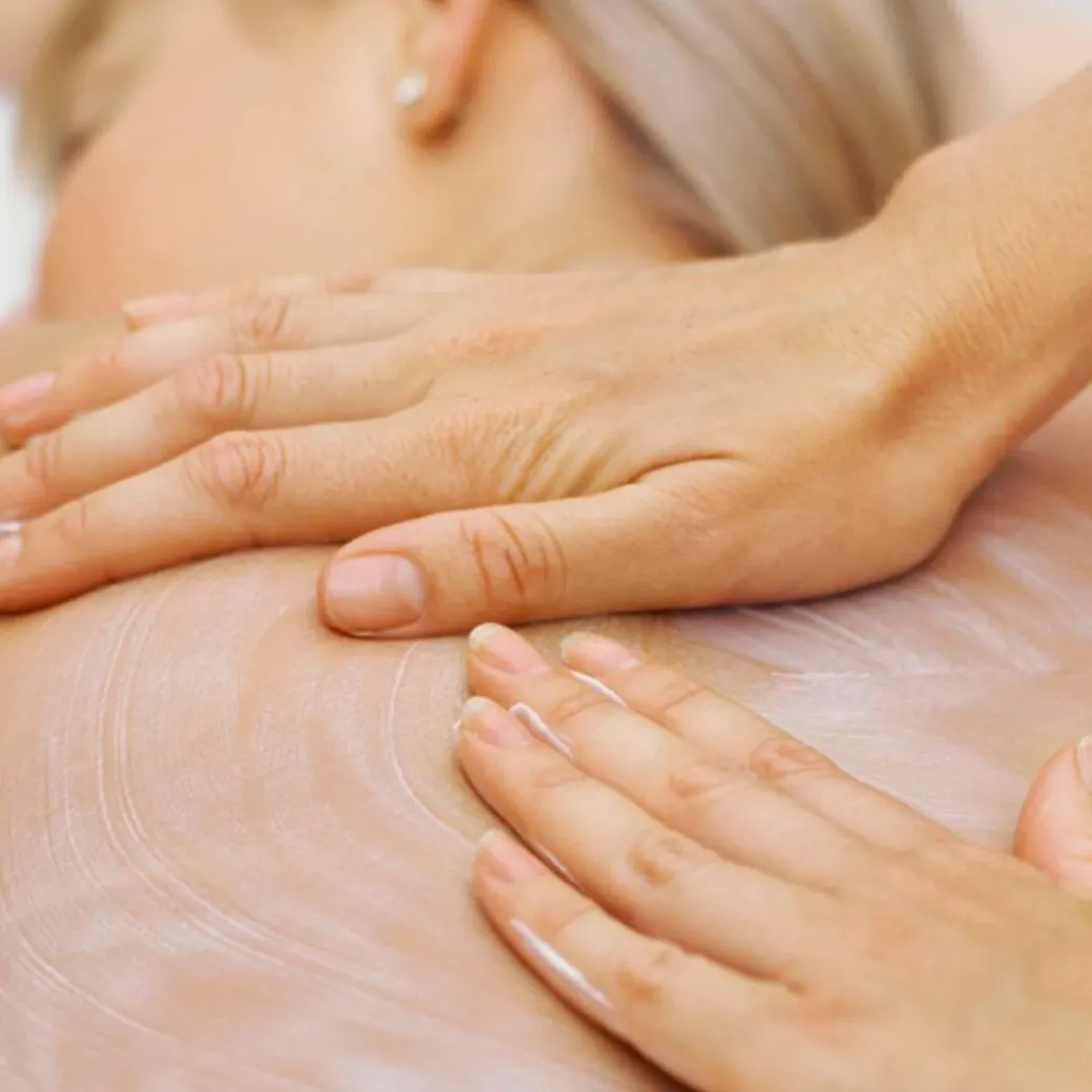Mãos da esteticista durante uma massagem de drenagem
