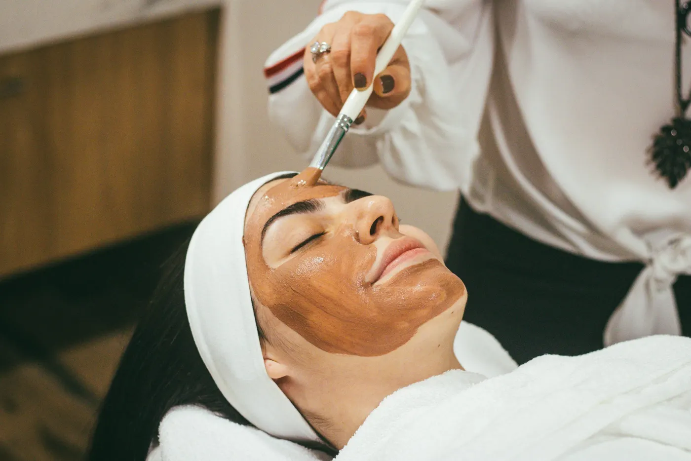 Esteticista a aplicar uma máscara de rosto com pincel