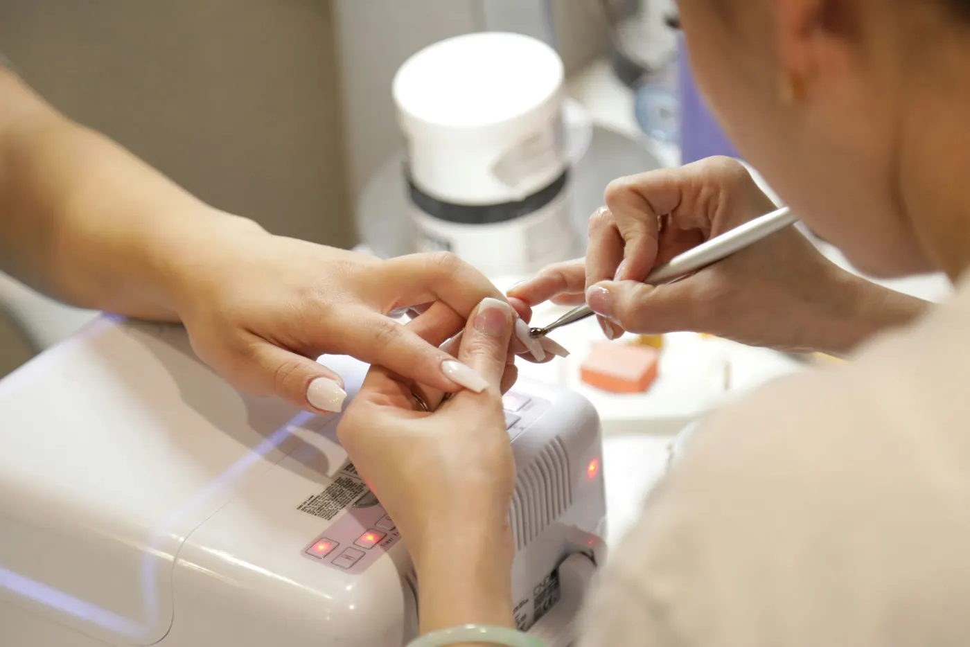 Manicure a tratar as unhas de uma cliente